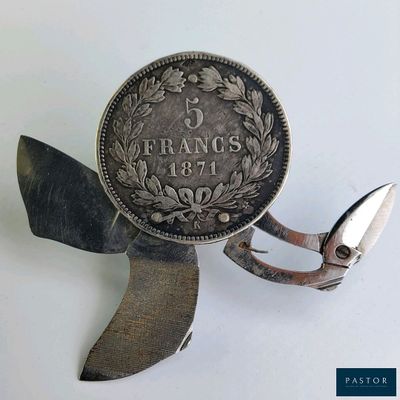 un petit morceau de métal sur lequel est posée une pièce de monnaie