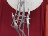 une sculpture métallique représentant une note de musique posée sur une table