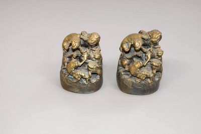 paire de figurines en bronze représentant un garçon et une fille assis sur un rocher