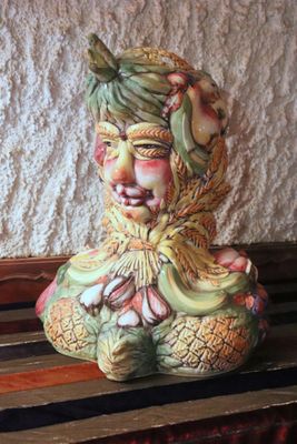 a ceramic figurine sitting on a wooden bench