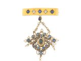 une image d'une broche « broochle » dorée et bleue ornée de perles