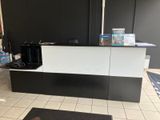 une photo d'un comptoir d'accueil noir et blanc dans un hôtel