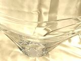 un vase en verre transparent posé sur une nappe blanche, sur une table