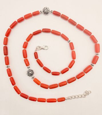 a close up of a necklace and bracelet on a white surface