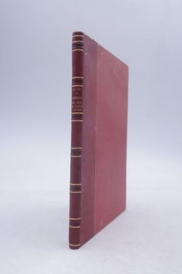 an old book sitting on top of a white table next to a white wall