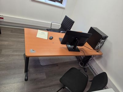 un bureau avec deux ordinateurs et une chaise dans un coin