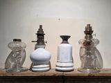 quatre bouteilles en verre posées les unes à côté des autres sur une étagère