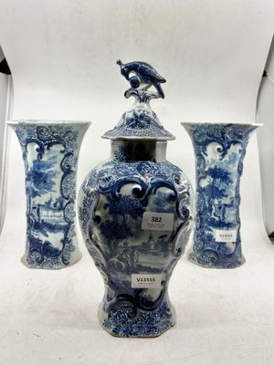 trois vases bleus et blancs posés sur une surface blanche