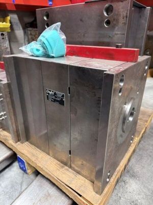 une grande caisse métallique posée sur une palette dans un entrepôt