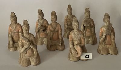 Plusieurs figurines représentant des personnages asiatiques sont exposées sur une surface blanche.