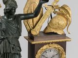 a statue of a woman holding a clock with a bird on it