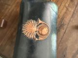 a black leather case with a picture of a bird on it