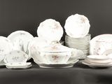 beaucoup d'assiettes et de tasses blanches sur une table noire