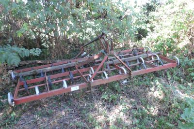 une charrue de tracteur qui est posée dans l'herbe