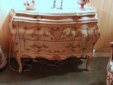 a dresser with a mirror on top of it next to a chair