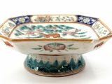 a small bowl with a design on it on a white surface