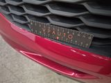 a close up of a red car with a ruler on the front of it