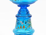 un bougeoir en verre bleu sur fond blanc