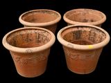 four clay pots are lined up in a row on a black background