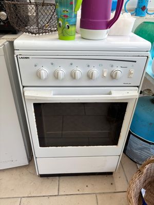 un four de cuisine blanc posé à côté d'une machine à laver