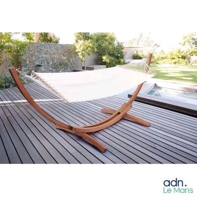un hamac suspendu à un support en bois sur la terrasse