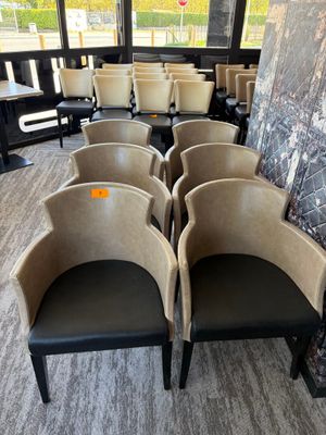 Plusieurs chaises sont alignées dans une salle d'attente dont l'un des murs est en marbre.
