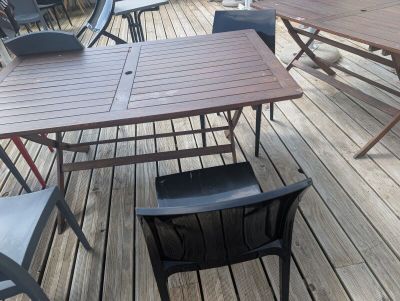 a table and chairs on a wooden deck with a view of the ocean