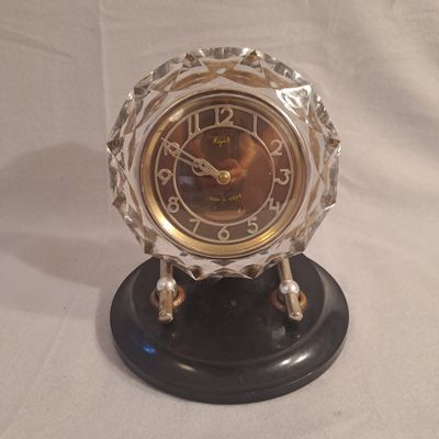 une horloge posée sur un support sur une table