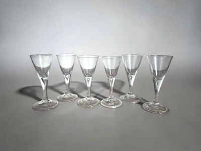 six verres à vin vides alignés sur une table