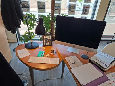 un bureau sur lequel se trouvent un ordinateur, un clavier, une souris et d'autres objets