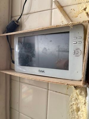 un micro-ondes posé sur une étagère dans un coin de la pièce