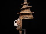 a wooden sculpture of a person ' s head on a stand
