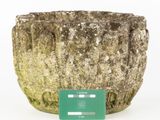 a stone planter with a green label on it