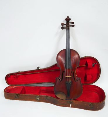 un violon posé dans son étui sur une surface blanche