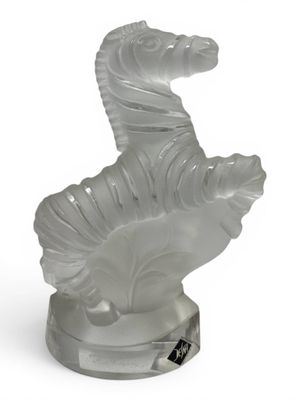 crystal figurine of a horse on a stand on a white background