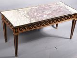 une photo d'une table basse au plateau en marbre sur fond gris