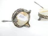 two silver objects that are sitting on a white surface