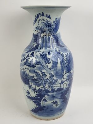 un vase bleu et blanc posé sur une surface blanche