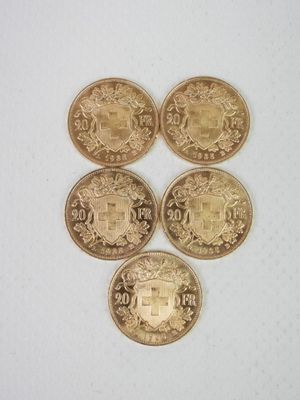 quatre types différents de pièces d'or sur une surface blanche