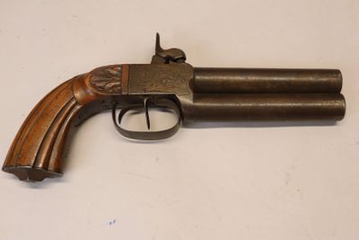 gros plan d'un pistolet sur une table à fond blanc
