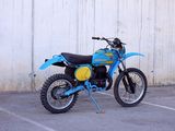 a blue and yellow dirt bike parked in a parking lot