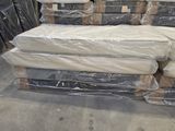 a pile of mattresses sitting on a pallet in a warehouse