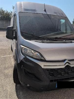 the front of a silver van is parked in a parking lot