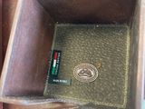 a brown leather case with a pen and a cell phone in it