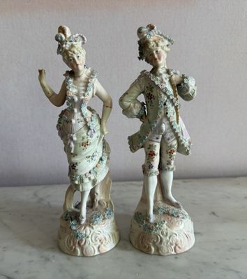 deux figurines d'un homme et d'une femme debout l'un à côté de l'autre