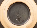 a close up of a brown vase with a black bottom
