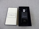 a black and white box with a bottle of perfume in it