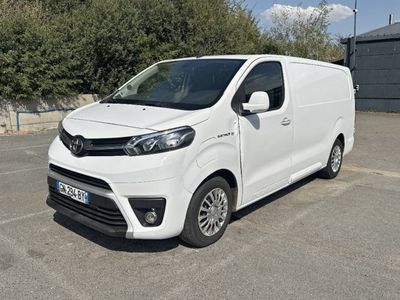 La camionnette blanche est garée sur le parking près des arbres.