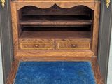 a close up of a wooden cabinet with a blue rug on the floor