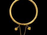 a close up of a gold bracelet with a chain and a heart